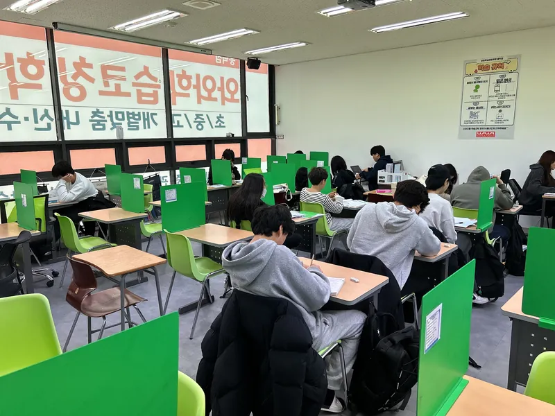 고등 수학학원 책상에서 교재를 살펴보는 학습 공간